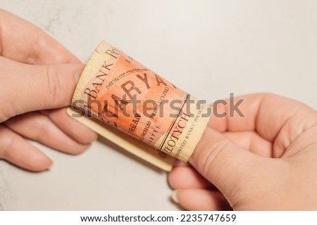 Hands twist old banknote with face value of 100 zloty, 1986. Polish money. People's Bank of Poland.  The inscription Proletariat Royalty-Free Stock Photo #2235747659