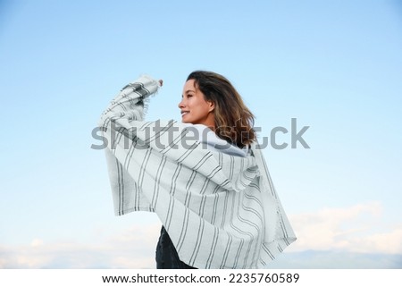 Portrait of beautiful young woman against blue sky Royalty-Free Stock Photo #2235760589