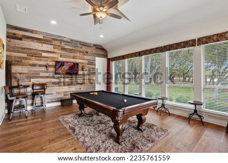 A pool table in a room with big windows Royalty-Free Stock Photo #2235761559