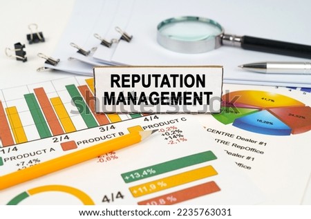 Business concept. On the business charts lies a magnifying glass, a pen and a sign with the inscription - Reputation Management Royalty-Free Stock Photo #2235763031