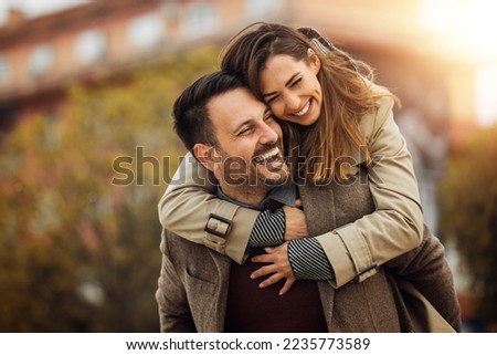 Loving young couple hugging and smiling together outdoors. Royalty-Free Stock Photo #2235773589