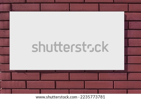 Empty white banner with isolated space for mockup fixed on red brick wall outdoor at city street