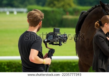 young reporter prepares footage about horse racing