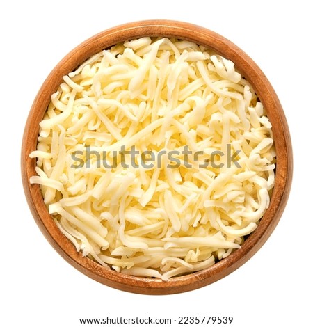 Shredded mozzarella cheese, in a wooden bowl. Grated low-moisture part-skim mozzarella, an Italian cheese, made of pasteurized cow milk, rolled in starch to avoid sticking. Used for pizza and pasta. Royalty-Free Stock Photo #2235779539