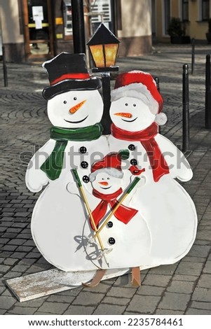 Winter snowman family. Mother, father and child  on skis.  New Year's decoration on the streets of the city.