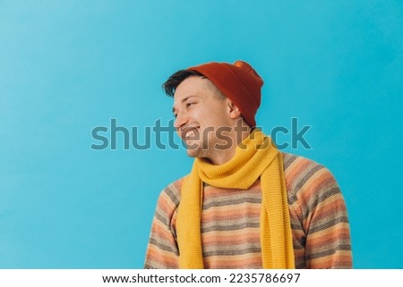 Handsome young man in winter clothes on color background
