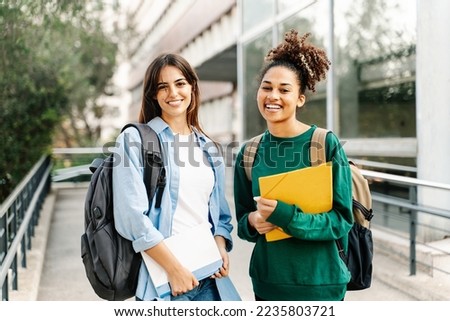 Two College Student female friends smiling ready for classes at the University campus Royalty-Free Stock Photo #2235803721