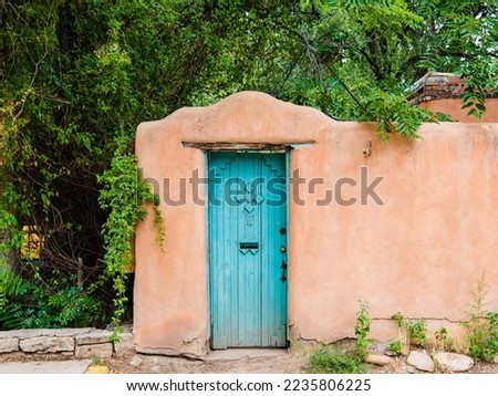 Wood turquoise colored door set in an old adobe wall in Santa Fe, New Mexico Royalty-Free Stock Photo #2235806225