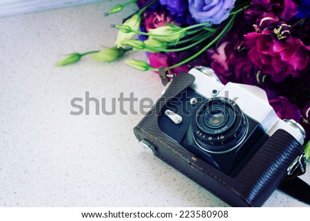 vintage   photo camera with flowers on table  with copy space
