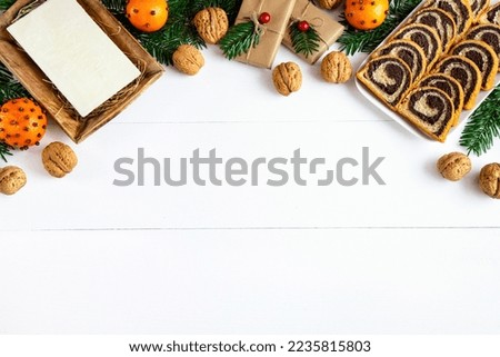 Christmas background with wafer, poppy seed cake, gifts, nuts, tangerines and fir branches
