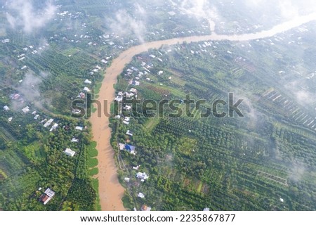 aerial view of Villa house in the middle of the garden with blue tile roof and the river at Mekong river delta VietNam countryside, Thai house building style. 