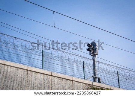 electric train energy cables and traffic light. razor safety mesh wires. 
