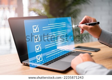 Digital work checklist on virtual screen concept, Businessman use a pen point on checklist and use laptop working in office Document Management System and process automation to efficiently manage file Royalty-Free Stock Photo #2235871243
