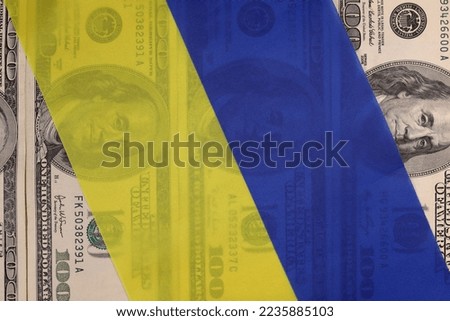 Ukrainian flag on the background of American dllars. The concept of lend lease, war in Ukraine, financial donations, America's aid Royalty-Free Stock Photo #2235885103