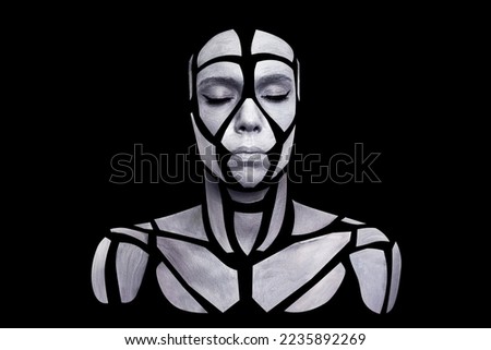 Portrait of person with art creative grey makeup posing in the studio. Shape of gray polygons on beautiful face, shoulders, neck. Pieces of face isolated on black background.