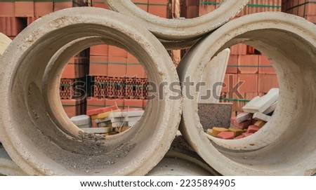 Concrete circles for a well and construction. Goods in stock, construction and repair of houses, delivery and sale of building materials.