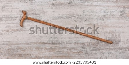 wooden walking stick on old white wooden background Royalty-Free Stock Photo #2235905431