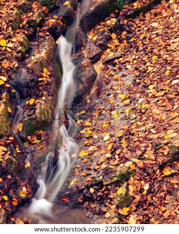 Long exposure shot of the Oblique Waterfall in Óbánya, Hungary in the autumn forest