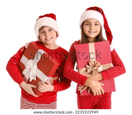 Little children in Santa hats with Christmas gifts on white background