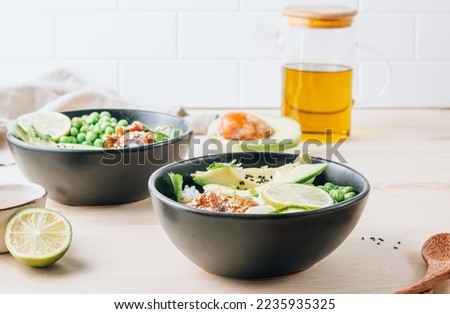 Buddha bowl with crispy sesame chicken asian style. Sweet and sour fried chicken with steamed rice, peas and acocado Royalty-Free Stock Photo #2235935325