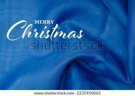 blue silk fabric with Merry Christmas inscription. High quality photo