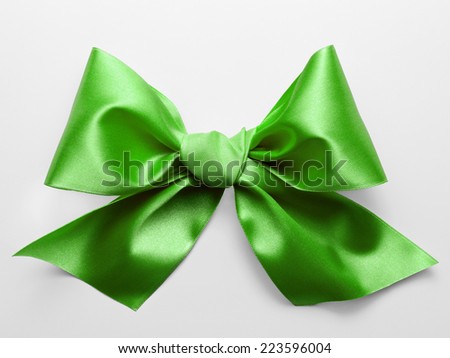 Green ribbon bow with real shadow on white background