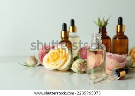 Skin care concept with essential rose oil on white background