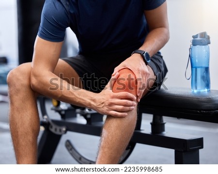Exercise, man and knee pain in gym, bench and injury after practice, workout and fitness. Healthy male, athlete and training for wellness, healthcare and muscle tension with intense joint strain. Royalty-Free Stock Photo #2235998685