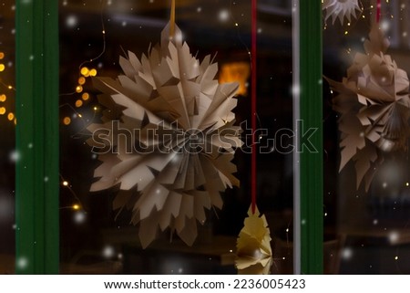 Christmas brown kraft paper snowflake decoration in the window. winter street decorations