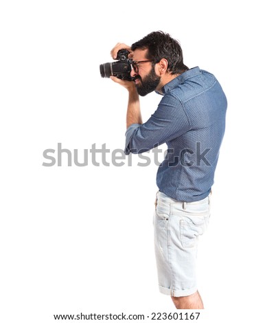 Young hipster man photographing over white background