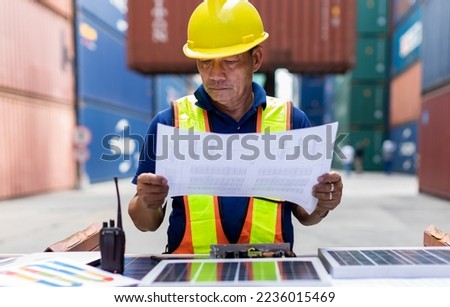 Foreman man working checking Document shipping  at Container cargo harbor to loading containers. Professional foreman holding document work at Container cargo site check up goods in container. 