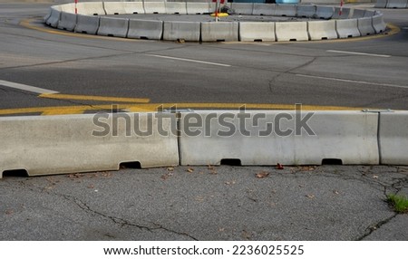 horizontal road marking lanes. highway concrete barriers on the road. vehicle collision lane separator. yellow color with black stripes. the road roundabout  concrete barriers Royalty-Free Stock Photo #2236025525