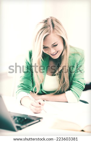 picture of smiling student girl writing in notebook