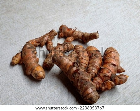 Fresh turmeric isoalted on wooden plank background. Selective focus.