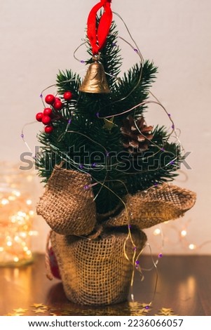 Christmas tree and Christmas lights. A bell with a red ribbon. New Year's background. Traditional home decoration for winter holidays. Home decoration for Christmas party. Golden stars