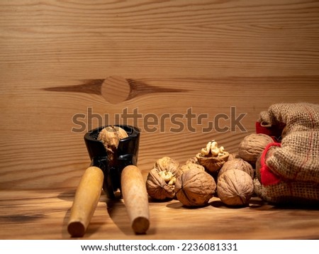 Walnut and nutcracker on a wooden background. Raw walnut. Close-up.