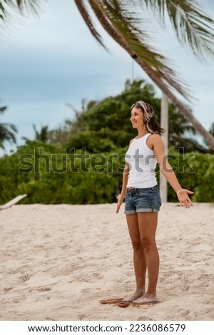  a fit adult woman with a sporty figure stands on Sadhu boards during yoga practice, concentration meditation, on a sandy sea beach
