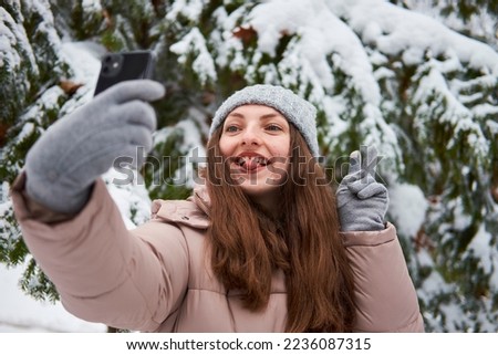 A smiling girl takes a selfie in winter.