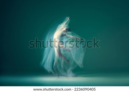 Emotions in dance. Graceful ballet dancer dancing with white cloth, fabric isolated on green background. Concept of art, motion, action, flexibility and inspiration concept. Blurring effect Royalty-Free Stock Photo #2236090405