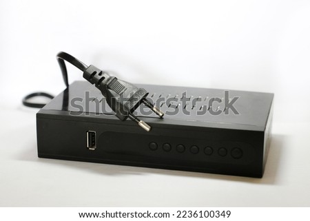 set top box or called STB, a digital television signal converter, black in color with a plain white background