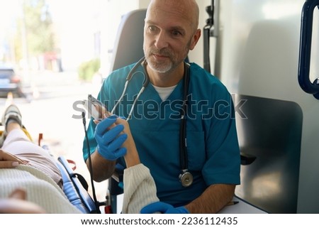Doctor looking at patient on gurney in mobile care salon Royalty-Free Stock Photo #2236112435