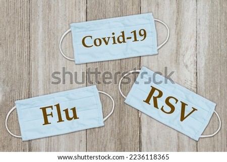RSV, covid-19 and flu message on face masks on weathered wood Royalty-Free Stock Photo #2236118365