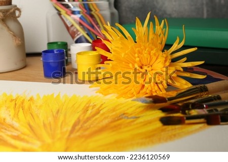 Painting of chrysanthemum on canvas, flower, colorful paints and brushes, closeup