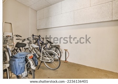 two bikes parked in a room with no one bike on the floor and another standing next to each other bicycles Royalty-Free Stock Photo #2236136401