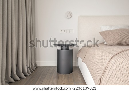 White wall lamp above the bed, metal beside table, white electrical outlet, oak wooden floor.
Modern minimalist aesthetic bedroom interior design in warm shades Royalty-Free Stock Photo #2236139821