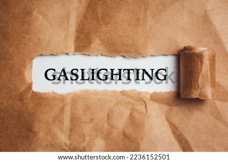 the word Gaslighting appearing behind torn brown paper.
 Royalty-Free Stock Photo #2236152501