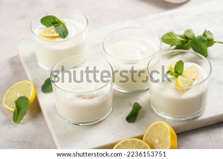 Creamy dairy yoghurt dessert sweet mousse with mascarpone, cream cheese, mint and lemon juice in glasses on marble tray Royalty-Free Stock Photo #2236153751