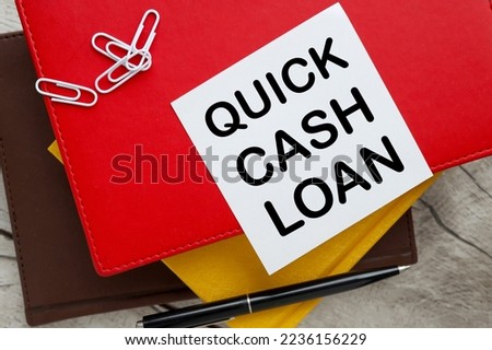 Business concept. QUICK CASH LOAN text on white paper on red diary