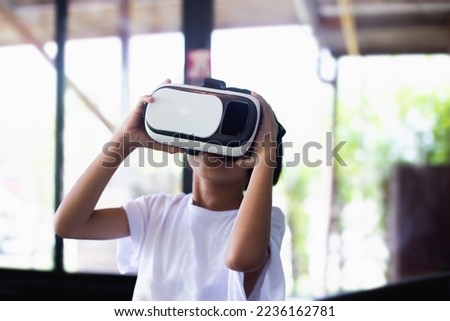Young girl kid child play virtual reality game hold vr glasses and surprised. Cyber space and virtual gaming