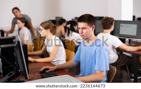 Modern boy student learning basics of programming in group course in computer college Royalty-Free Stock Photo #2236164673